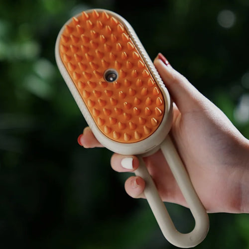 Brosse vapeur Brumi tenue en main, picots orange